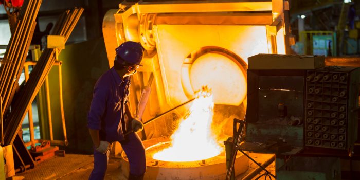 Operator remove slag from electric induction crucible melting furnace, Iron melting for foundry iron casting part, heavy industry of automotive part manufacturing factory, High temperature melting furnace.